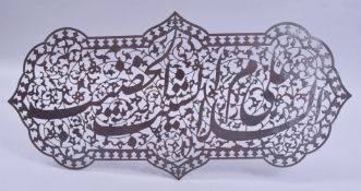 AN ISLAMIC OPENWORK CALLIGRAPHIC STEEL PLAQUE, 46.5cm wide.