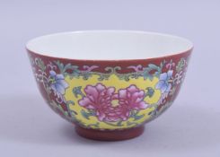 A SMALL CHINESE RED GROUND PORCELAIN BOWL, painted with panels of native flora, six character mark