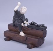 A JAPANESE MEIJI PERIOD MIXED MEDIA OKIMONO - WOODWORKER, the man formed from bronze and ivory