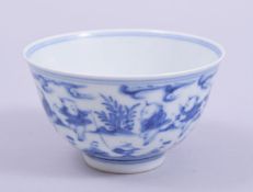 A CHINESE BLUE AND WHITE PORCELAIN TEA BOWL, the exterior painted with boys in a landscape, the