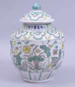 A CHINESE MING STYLE SANCAI JAR AND COVER, the body decorated with fish and algae, with six