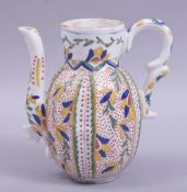 A TURKISH KUTAHYA GLAZED POTTERY EWER, painted with panels of foliate design, 16.5cm.