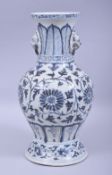 A CHINESE BLUE AND WHITE TWIN HANDLE PORCELAIN VASE, painted with large flower heads and vine,