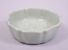 A SMALL CHINESE CELADON GLAZED DISH, the base with six character mark, 11cm diameter.