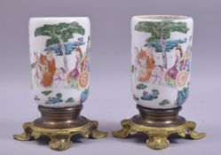 A PAIR OF CHINESE FAMILLE ROSE PORCELAIN VASES, mounted to ormolu stands, the body of each painted