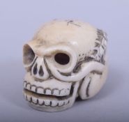 A JAPANESE MEIJI PERIOD CARVED IVORY NETSUKE - SKULL, the skull with a millipede climbing out of the