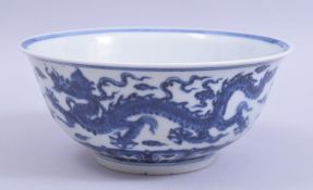 A CHINESE MING STYLE BLUE AND WHITE PORCELAIN BOWL, painted with dragons amongst stylised clouds,