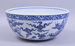 A LARGE CHINESE MING STYLE PORCELAIN BOWL, the exterior painted with dragons and stylised clouds,
