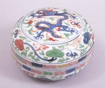 A CHINESE WUCAI PORCELAIN CIRCULAR BOX AND COVER, the cover painted with a dragon and the flaming