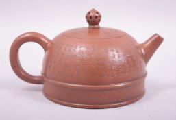 A CHINESE YIXING TEAPOT, the exterior with calligraphy, the cover with impressed mark inside as well