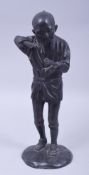A JAPANESE MEIJI BRONZE FIGURE OF A FARMER HOLDING A PIPE, on a circular bronze base, 29.5cm high.