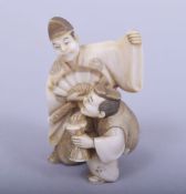 A JAPANESE MEIJI PERIOD CARVED IVORY NETSUKE - KARAKO ACTORS, one man holding his fan beside a man