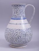 A TURKISH IZNIK GLAZED POTTERY WATER JUG, decorated with bands of scrolling foliate design, 25.5cm