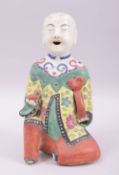 A CHINESE REPUBLIC FAMILLE VERTE PORCELAIN FIGURE OF A BOY holding a peach, 19cm high.