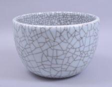 A LARGE CHINESE CRACKLE GLAZE GUAN WARE BOWL, six character mark to base, 22cm diameter.