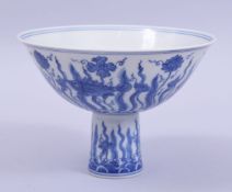 A CHINESE BLUE AND WHITE PORCELAIN STEM CUP, the exterior painted with fish and flora above stylised