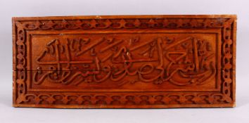 AN ISLAMIC TURKISH CARVED WOODEN CALLIGRAPHY PANEL, 61cm x 25cm.