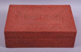 A RED LACQUER HINGED LIDDED BOX, POSSIBLY CAMBODIAN, profusely decorated with bands of scrolling