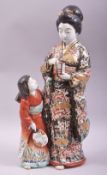 A JAPANESE KUTANI PORCELAIN GROUP, modelled as a mother and child, 37cm high.