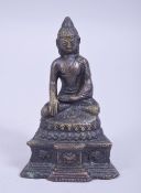 A CHINESE BRONZE FIGURE OF A SEATED DEITY, sat in meditation with dragon and elephant decoration,