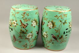A PAIR OF CHINESE GREEN PORCELAIN BARREL SEATS, flowers and birds. 18ins high.