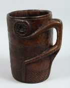 A CARVED WOOD TRIBAL MUG/VESSEL carved out of the solid.