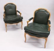 A PAIR OF FRENCH ARM CHAIRS with padded leather seats, back and arms, supported on curving legs.