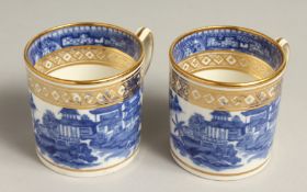 A PAIR OF STAFFORDSHIRE BLUE, WHITE AND GILT COFFEE CANS with rare handles, circa. 1815.