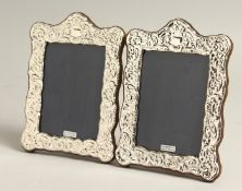 A PAIR OF SILVER REPOUSSE PHOTOGRAPH FRAMES 7.5ins x 5.5ins