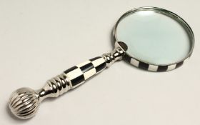 A MAGNIFYING GLASS WITH CHECKERED AND CHROME HANDLE.