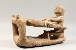 A CARVED LAVA INUIT SLEDGE AND RIDER. 14ins long 10ins high.