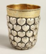 A LARGE SILVER AND SILVER GILT BEAKER decorated with hearts. 3.75ins high, engraved LUCERNE 1964.