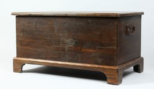 A PINE WOODEN BOX with lid, on bracket feet. 23ins long