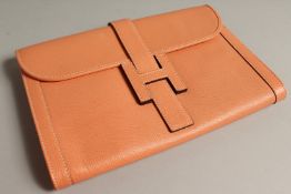 A LADIES PEACH LEATHER CLUTCH BAG.