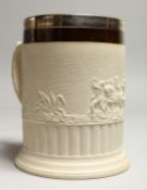 AN 18TH CENTURY POTTERY MUG with a scene of classical figures and chariots in relief, with plated