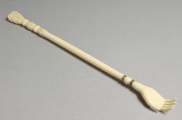 A 19TH CENTURY EUROPEAN IVORY CARVED BACK SCRATCHER, one end with a hand, the other with bobbin type