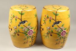 A PAIR OF CHINESE YELLOW PORCELAIN BARREL SEATS, flowers and birds. 18ins high.
