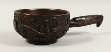 A LARGE AMERICAN CARVED WOODEN SCOOP, the sides carved with snakes with American eagle handles. 7ins