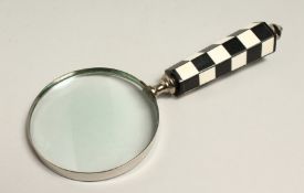 A MAGNIFYING GLASS WITH CHECKERED HANDLE.