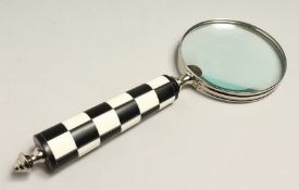 A MAGNIFYING GLASS WITH CHECKERED HANDLE.