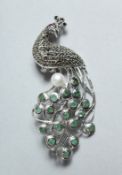 A SILVER, MARCASITE, EMAERALD AND PEARL PEACOCK BROOCH.