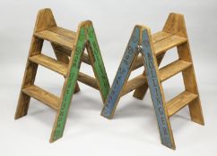 A PAIR OF FOLDING WOODEN STEPS decorated to the sides with Champagne producers. 32ins high