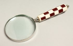 A MAGNIFYING GLASS WITH RED CHECKERED HANDLE.