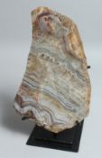 A LARGE SLICE OF AGATE 10.5ins x 7ins on a metal stand.