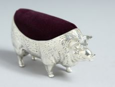A LARGE WHITE METAL PIG PIN CUSHION