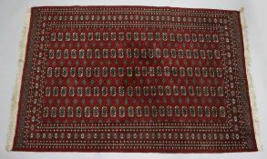 A BOKHARA CARPET, red ground with five rows of twenty three gulls. 9ft 4ins x 6ft 3ins.