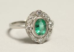 A GOOD 18CT GOLD, EMERALD AND DIAMOND CLUSTER RING