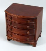 A MINIATURE MAHOGANY BOW FRONT CHEST OF DRAWERS, four long graduated drawers with wooden handles