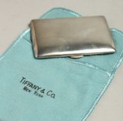 A TIFFANY & CO. SILVER COMPACT in a cloth case.