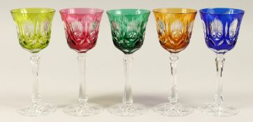A SET OF FIVE CUT GLASS WINE GLASSES, one green, one bright green, one amber ,one blue,one ruby. 8.